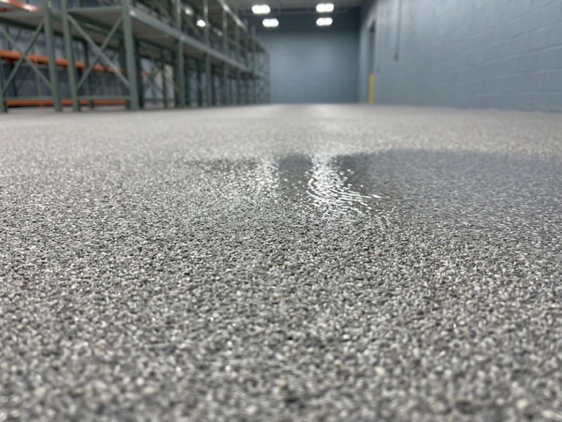 Textured anti-slip epoxy floor with aggregate broadcast into the topcoat, wet surface