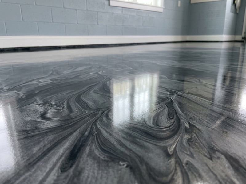 Marbled charcoal and pewter metallic epoxy floor with a high-gloss reflective finish